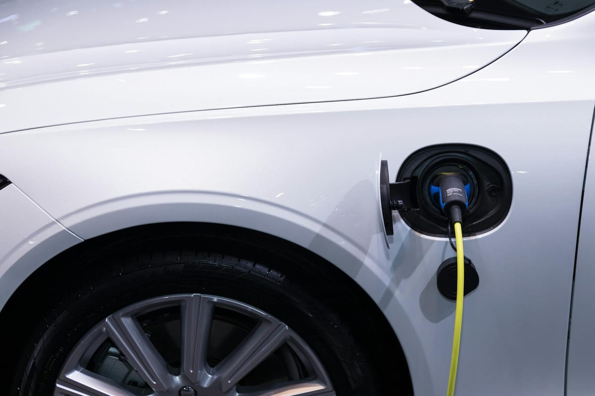 Voiture électrique blanche en charge — illustrant les aides 2026 pour remplacer un véhicule polluant en Île-de-France