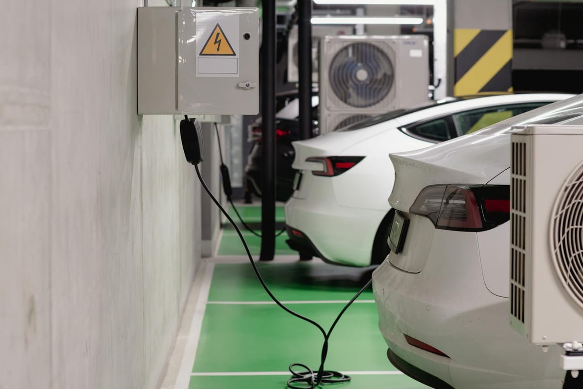 Voitures électriques en charge dans un parking équipé de bornes — passage à un véhicule propre soutenu par les aides 2026